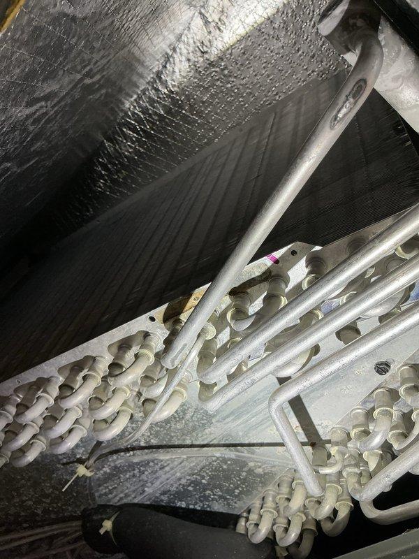 Completed annual cooling maintenance on HVAC system. Inspected refrigerant line sets, verified system electrical readings with multimeter showing 67.9 reading, and checked attic installation components including insulated copper tubing and air handler. Replaced air filter and evaporator pad as scheduled.