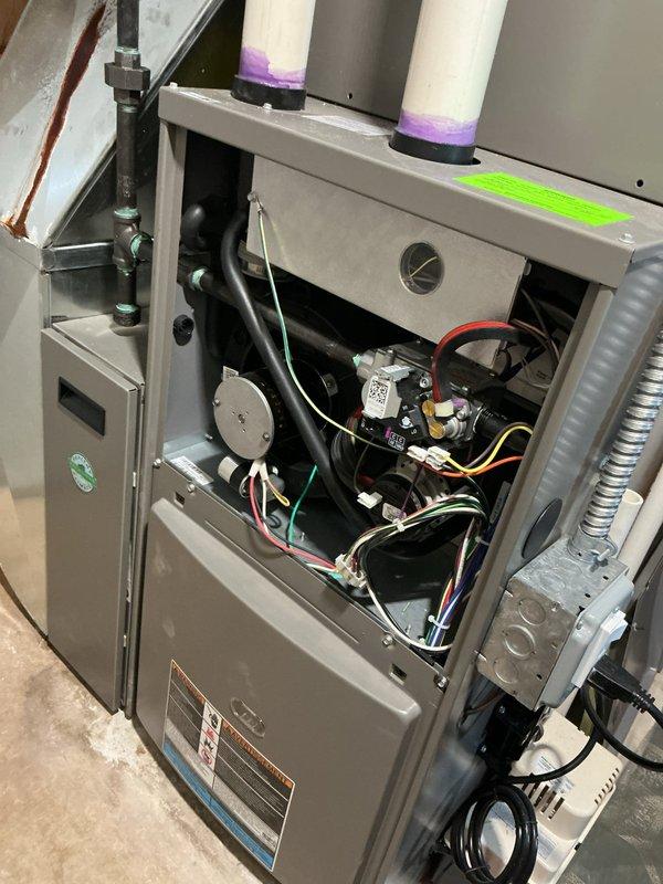 Performed comprehensive ComfortGuard maintenance package on residential HVAC system. Inspected indoor furnace unit with access panel removed, verifying proper operation of gas valve assembly, pressure switch, ignition components, and all electrical connections. Examined outdoor condenser unit, confirmed refrigerant lines secure, checked fan operation, and verified unit level and stable on pad. All system components operating within normal parameters; no deficiencies noted during inspection.