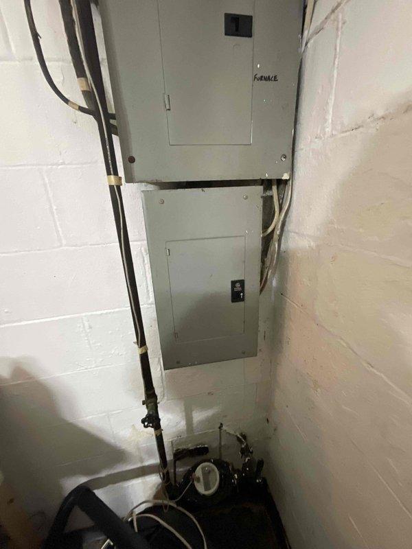 Conducted on-site assessment for complete HVAC system replacement in basement location. Evaluated existing 2003 furnace and air conditioning equipment, noting air conditioning unit has been inoperative for two years. Documented current equipment configuration and electrical service setup in utility room area. Photographed existing installation including furnace electrical panel, conduit routing, and mechanical equipment positioning to prepare comprehensive replacement estimate for both heating and cooling systems.