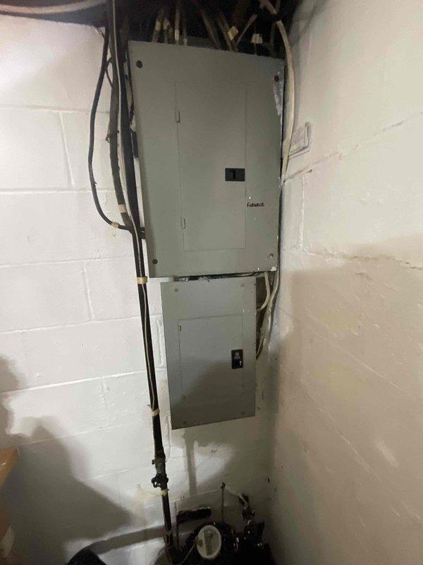 Conducted on-site assessment for complete HVAC system replacement in basement location. Evaluated existing 2003 furnace and air conditioning equipment, noting air conditioning unit has been inoperative for two years. Documented current equipment configuration and electrical service setup in utility room area. Photographed existing installation including furnace electrical panel, conduit routing, and mechanical equipment positioning to prepare comprehensive replacement estimate for both heating and cooling systems.