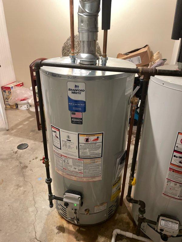 Completed installation of a 50-gallon Bradford White tanked water heater in basement utility room. Removed existing unit, installed new water heater with proper venting connections, connected copper supply and discharge lines with appropriate insulation, installed pressure relief valve with discharge piping, and verified all plumbing connections for proper operation. Work performed under valid mechanical permit, all code requirements met, and system tested successfully upon completion.
