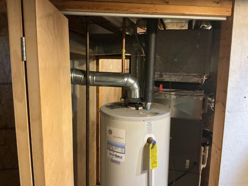 Completed full HVAC system installation including 70,000 BTU furnace with humidifier and liner, 2-ton air conditioning unit with left-side configuration, and new dedicated electrical circuit. Mechanical and electrical permits obtained prior to installation. All equipment installed in basement utility area with proper venting, ductwork connections, and electrical service established per code requirements.