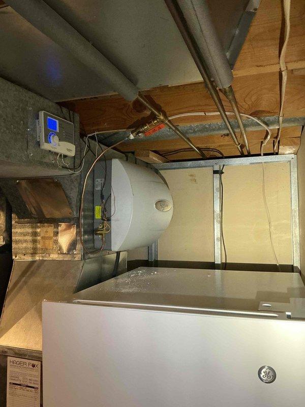 Responded to service call for water leak of unknown origin in residential HVAC system. Upon arrival, performed visual inspection of furnace, air handler, water heater, and associated plumbing connections in basement utility area. Examined condensate drain lines, PVC piping, copper water lines, and all visible connections for signs of active leaking or moisture accumulation. Inspected furnace cabinet interior components, blower assembly, and drain pan for water presence. Checked water heater connections and relief valve for potential leak sources. Documented equipment conditions with photos showing furnace with open access panel, internal components, condensate piping, water softener system, air handler unit, and water heater installation. No active leak identified during inspection period. Advised monitoring system for recurrence and recommended callback if leak reappears for further diagnostic evaluation.