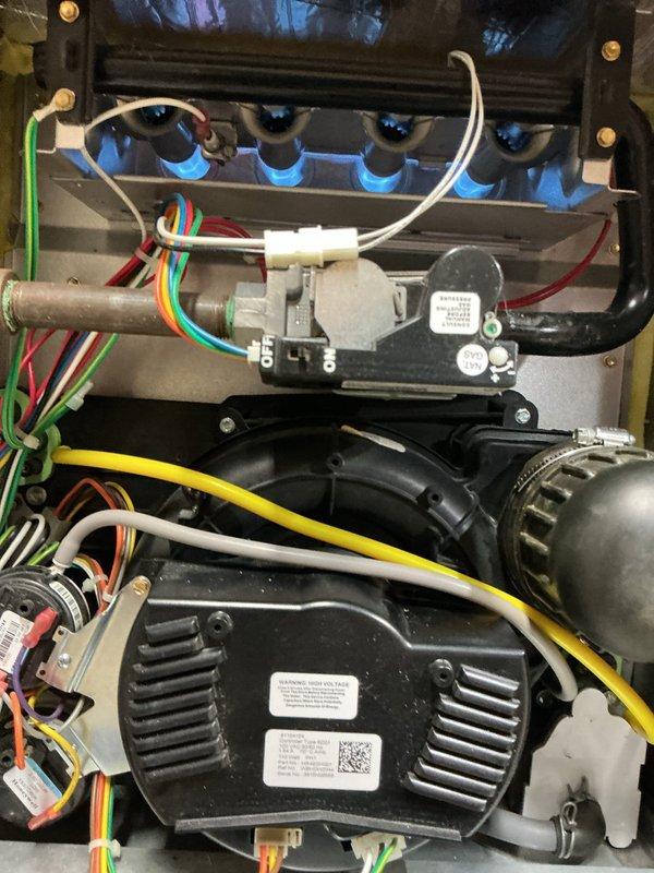 Responded to no-heat call on forced air furnace system. Upon arrival, performed diagnostic inspection of unit located in unfinished mechanical room. Visual inspection revealed blue burner assemblies and internal blower components in good physical condition. Tested electrical connections and control board wiring harness, noting proper wire terminations at white connector housing. Examined blower motor assembly and capacitor for signs of failure. Checked gas valve operation and ignition sequence. Cycled unit through startup sequence to identify failure point. System components showed no visible signs of age-related deterioration or mechanical failure. Documented internal components and mechanical room setup with diagnostic photographs. Completed walkthrough inspection with homeowner regarding findings and operational status.