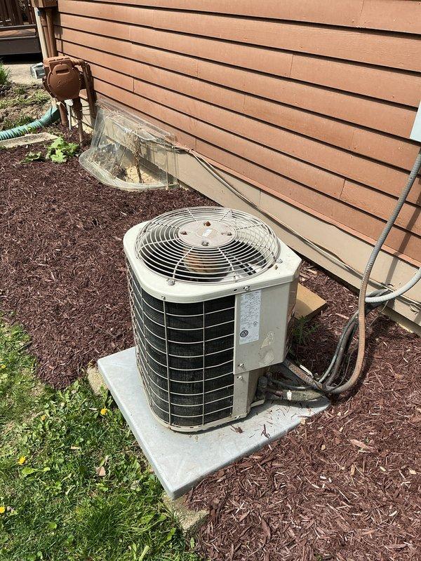 Completed comprehensive tune-up on 24-year-old residential air conditioning system. Performed full inspection of outdoor condenser unit, including visual assessment of cabinet condition, refrigerant line connections, and electrical disconnect box. Unit showed signs of age-appropriate weathering but remained operational on concrete pad with proper clearances maintained from building structure and landscaping.
