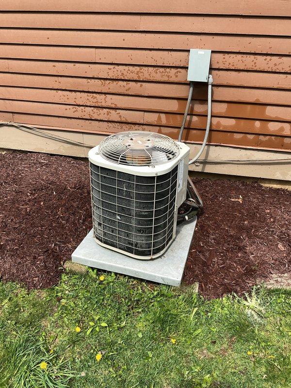 Completed comprehensive tune-up on 24-year-old residential air conditioning system. Performed full inspection of outdoor condenser unit, including visual assessment of cabinet condition, refrigerant line connections, and electrical disconnect box. Unit showed signs of age-appropriate weathering but remained operational on concrete pad with proper clearances maintained from building structure and landscaping.