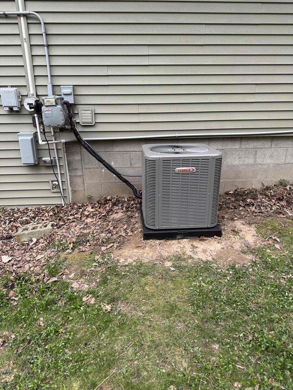 Completed full HVAC system installation including a 70,000 BTU Lennox furnace and 2.5 ton Lennox air conditioning condenser unit. Installed furnace in interior utility room with proper venting via white PVC exhaust piping, established electrical connections, and integrated ductwork to existing air distribution system. Mounted outdoor AC condenser on equipment pad against exterior wall with appropriate clearances, ran refrigerant line set and electrical disconnect, and completed all necessary connections between indoor and outdoor components. System tested and verified operational upon completion.