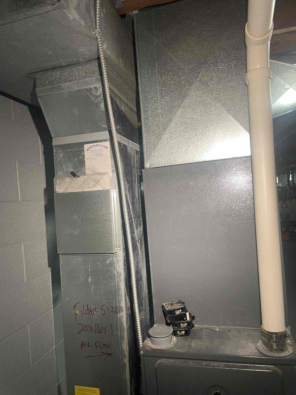 Conducted comprehensive evaluation of existing HVAC system for replacement estimate. Existing furnace approximately fifteen years old and nearing end of serviceable life. Assessed current three-unit stacked configuration including furnace and air conditioning components with associated refrigerant lines, electrical connections, and condensate drainage system. Documented existing equipment specifications, noting filter size requirements of 30x16x1 and current installation layout in basement mechanical room. Photographed complete system setup including copper refrigerant piping, electrical conduit routing, PVC condensate drain lines, and flexible ductwork connections to provide accurate replacement specifications. Evaluated installation space constraints and existing infrastructure to determine optimal replacement equipment sizing and configuration recommendations for complete furnace and AC system upgrade.