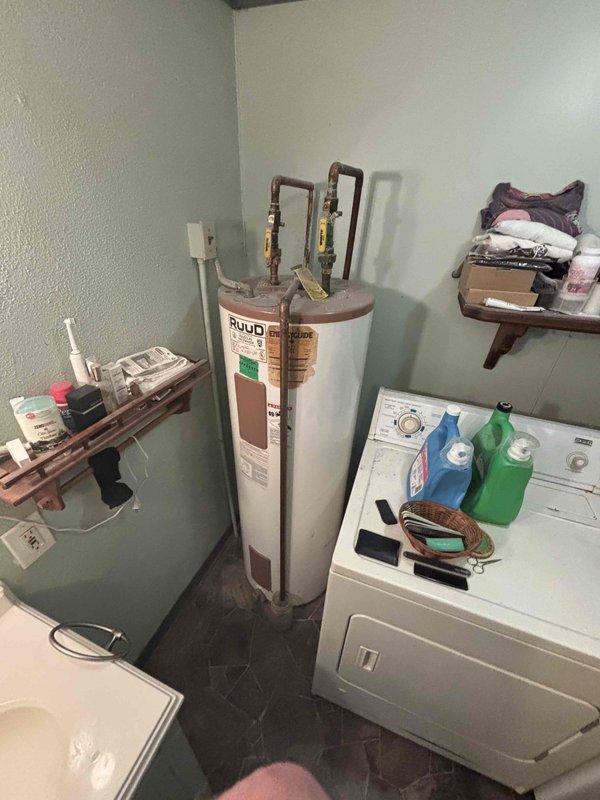 Provided estimate for water heater replacement in utility room. Existing RUUD water heater was not functioning and required full replacement. Assessed installation location, venting configuration, and plumbing connections including copper supply lines and brass valves to determine appropriate replacement unit specifications and installation requirements.