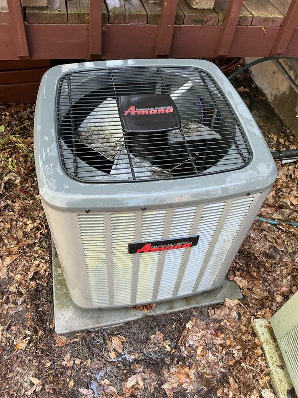 Completed annual maintenance on residential split HVAC system consisting of Lennox furnace and Amana outdoor condensing unit. Performed comprehensive inspection of indoor furnace installation, verifying proper ductwork connections, checking manufacturer labels and safety placards, and confirming adequate clearances within mechanical closet. Inspected outdoor condenser unit, noting accumulated organic debris around base and on ground pad. Cleaned condenser coils and surrounding area, removing leaves and twigs to ensure proper airflow and system efficiency. Verified refrigerant lines, electrical connections, and overall unit operation. Both indoor and outdoor components showed normal wear consistent with regular use. System operating within manufacturer specifications upon completion of maintenance procedures. Documented equipment conditions with photographs for service records.