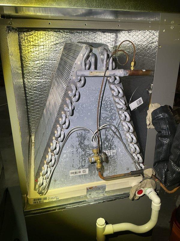 Completed annual cooling maintenance on residential HVAC system. Inspected indoor evaporator coil assembly showing frost accumulation on A-frame coil configuration, checked refrigerant lines and connections, verified condensate drain line operation, and examined outdoor condensing unit. Replaced air filters as part of routine preventive maintenance to ensure optimal system performance for the cooling season.