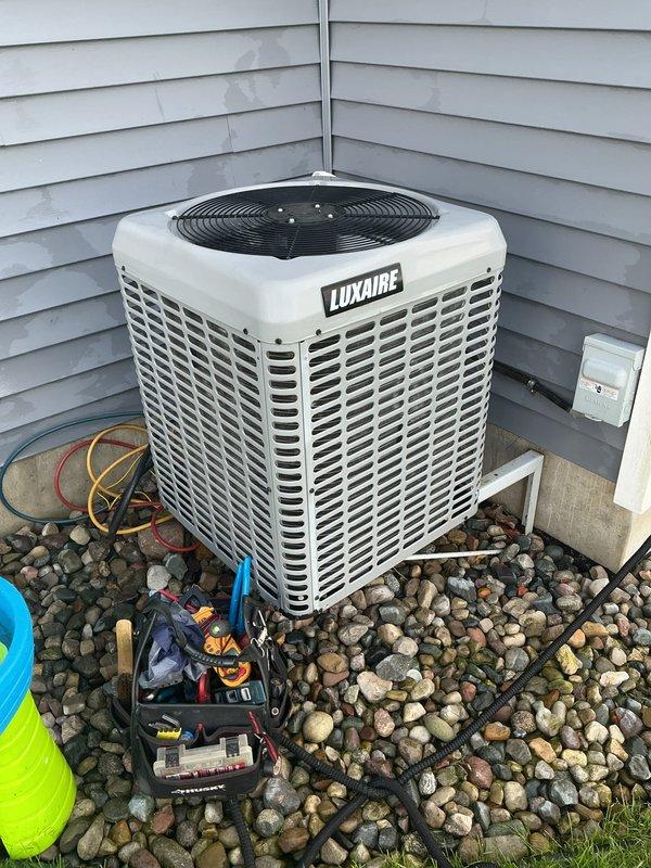 Completed comprehensive AC tune-up on 8-year-old Luxaire central air conditioning system. Performed standard maintenance protocol including refrigerant pressure checks using manifold gauges, inspected condensing unit exterior condition, verified proper airflow through louvered panels and top-mounted fan assembly, and examined electrical disconnect and line set connections. System operating within normal parameters with no deficiencies noted.