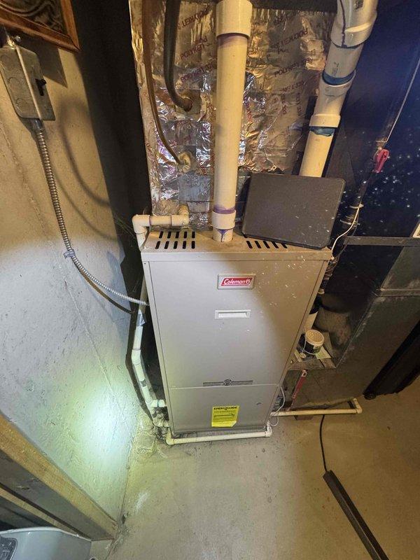Provided comprehensive estimate for replacement of 20-26 year old HVAC system located in basement, including non-functional natural gas furnace and operational air conditioning unit. Assessed existing Coleman furnace installation, evaluated ductwork configuration including flexible ducting, reviewed ventilation and drainage piping infrastructure with visible PVC connections, and documented current system layout with foil-backed insulation and copper refrigerant lines. Presented equipment replacement options for complete heating and cooling system upgrade to restore full climate control functionality.