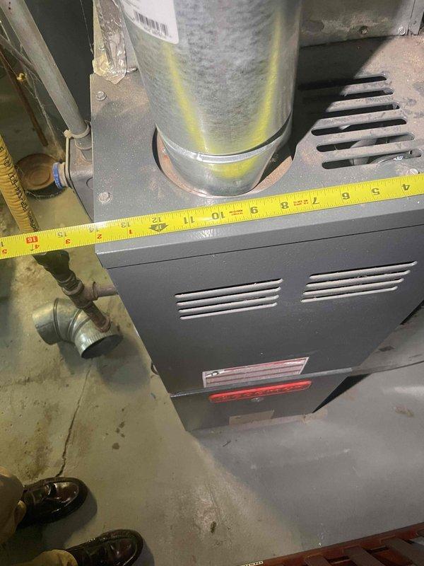 Conducted comprehensive assessment of existing 2006 furnace and air conditioning system located in basement for equipment replacement estimate. Documented current installation including furnace unit with existing ductwork connections and measured clearances for proper sizing of new equipment. Evaluated mini-split system as potential alternative solution based on site conditions and customer requirements.
