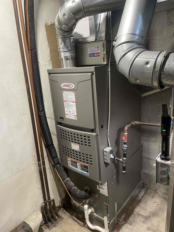 Completed furnace-only installation in residential basement utility room. Installed new Lennox 90,000 BTU high-efficiency furnace unit, securing equipment to concrete block wall per manufacturer specifications. Connected all supply and return ductwork using galvanized steel sections and appropriate elbows for proper airflow distribution throughout the system. Ran and connected gas supply line with shutoff valve for fuel delivery. Installed electrical disconnects and wiring to power unit and control systems. Routed condensate drain lines and refrigerant lines as needed for system operation. Verified all connections for proper fitment and sealed ductwork transitions to prevent air leakage. Tested furnace operation including ignition sequence, burner performance, and safety controls. Confirmed proper venting configuration and clearances meet code requirements. Obtained necessary mechanical and electrical permits prior to installation. All work completed to local building codes and manufac