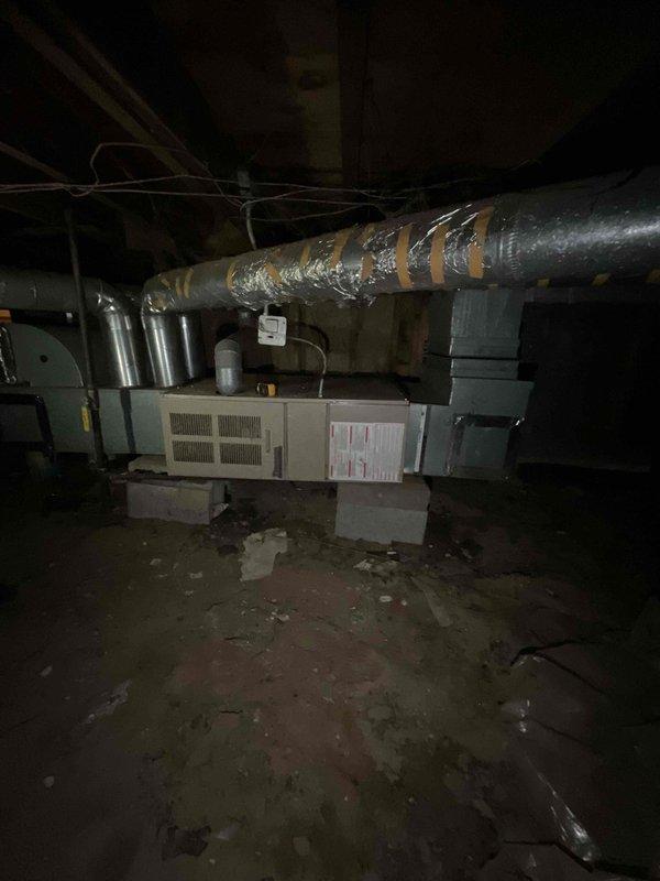 Conducted comprehensive site assessment for full HVAC system replacement in residential property with 1990s-era furnace and no existing air conditioning. Evaluated 16-year-old heating equipment located in basement mechanical room, documenting deteriorated ductwork insulation with multiple tears and exposed metallic surfaces requiring replacement. Inspected crawl space conditions, noting accumulated debris and compromised insulation materials that will need remediation during installation. Photographed existing equipment configuration, including aged air handling unit on concrete blocks, associated ductwork routing, and structural access points. Provided detailed estimate for complete furnace replacement and new air conditioning system installation to address immediate replacement needs.
