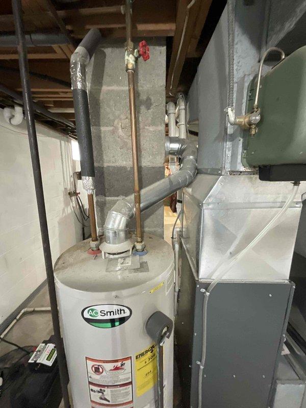 Conducted on-site assessment of existing A.O. Smith tank-style water heater in basement mechanical room to provide estimate for replacement with electric tankless unit. Evaluated current installation including copper supply lines, gas connections, electrical requirements, venting configuration, and available space constraints. Documented existing equipment specifications and mechanical room layout to determine feasibility and scope of converting from conventional tank water heater to tankless electric system.