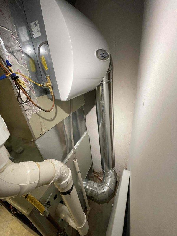 Provided estimate for replacement of basement-located natural gas furnace and air conditioning system under BOGO promotion. Current 12-year-old furnace operational but 30+ year-old AC unit not functioning. Documented existing HVAC equipment configuration including air handler with refrigerant lines, condensate drainage system, exterior utility connections, and electrical service components for replacement specifications.