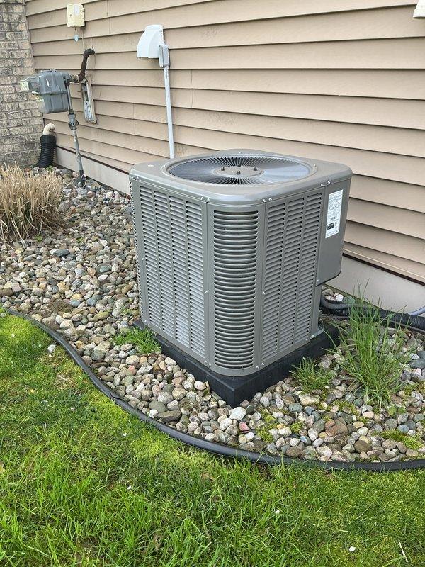 Completed annual cooling maintenance on residential air conditioning system. Performed comprehensive inspection of outdoor condenser unit, including visual assessment of cabinet condition, fan motor operation, and electrical connections at disconnect box. Verified proper unit placement on composite pad with adequate drainage through rock bed landscaping. Checked refrigerant line insulation and PVC condensate drain routing along exterior wall. Inspected electrical components including disconnect switch and conduit connections for proper operation and code compliance. Unit found to be in satisfactory operating condition with all components functioning within normal parameters.