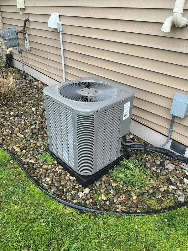 Completed annual cooling maintenance on residential air conditioning system. Performed comprehensive inspection of outdoor condenser unit, including visual assessment of cabinet condition, fan motor operation, and electrical connections at disconnect box. Verified proper unit placement on composite pad with adequate drainage through rock bed landscaping. Checked refrigerant line insulation and PVC condensate drain routing along exterior wall. Inspected electrical components including disconnect switch and conduit connections for proper operation and code compliance. Unit found to be in satisfactory operating condition with all components functioning within normal parameters.