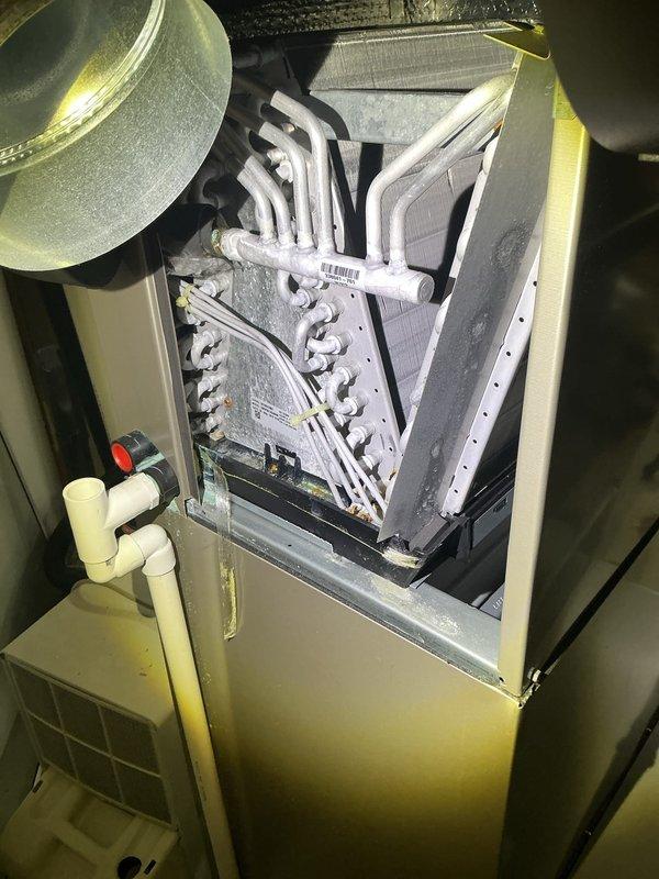 Completed annual cooling maintenance on residential HVAC system. Removed top access panel and performed comprehensive inspection of air handler unit and evaporator coil assembly. Verified refrigerant lines and insulation integrity on all white-insulated suction and liquid lines. Inspected heat exchanger fins and coil surfaces for cleanliness and proper condition. Checked control board and electrical connections for proper operation. Verified condensate drain lines and PVC drainage system are clear and functioning correctly. Inspected blower housing and ductwork connections at plenum. All components operating within normal parameters with no deficiencies noted.