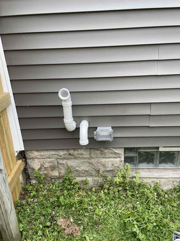 Completed full HVAC system installation including a 70,000 BTU furnace with liner and 2-ton air conditioning unit with right-side configuration. Installed new electrical circuit to support the system and ran all necessary ductwork connections in basement mechanical room. Mounted exterior condensate drain lines with PVC piping and cleanout access point on building exterior, securing all components to vinyl siding above foundation. Obtained mechanical and electrical permits prior to installation and documented completed work with photographs showing installed equipment and exterior penetrations.