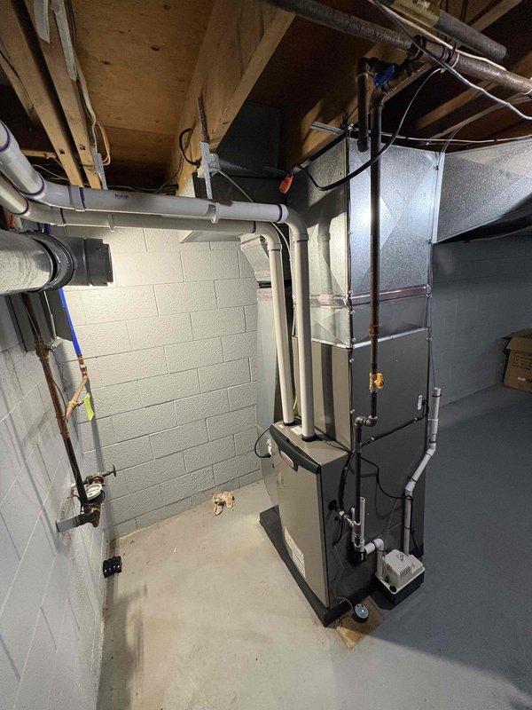 Completed full HVAC system installation in basement utility area, including 70,000 BTU gas furnace and 2-ton air conditioning unit. Secured all required mechanical and electrical permits prior to installation. Mounted furnace on platform base with proper clearances, connected PVC condensate drainage lines, and installed refrigerant line set with copper piping. Configured flexible ductwork to distribution system with metal banding and proper support from ceiling joists. Completed all electrical connections and reconnected system components to existing infrastructure. Verified proper operation of both heating and cooling systems upon startup. Installation meets all applicable building codes and manufacturer specifications.