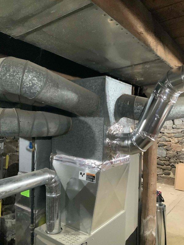 Completed estimate for replacement of 7-year-old natural gas furnace and air conditioning system located in basement with stone foundation walls. Current equipment is operational but customer seeking replacement options for direct venting configuration. Evaluated existing HVAC installation including white vertical air handler unit, flexible gray ductwork, metallic branch ducts, and copper refrigerant lines in residential mechanical room setting.