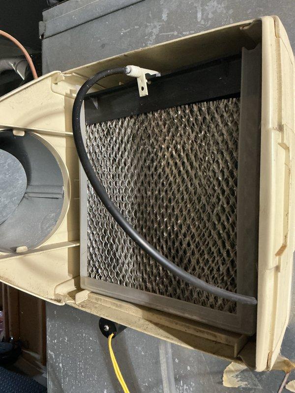 Completed annual cooling maintenance on residential HVAC system. Inspected evaporative cooler unit on rooftop, finding heavily soiled mesh filter pad with significant dust and debris accumulation. Checked indoor air handler unit in basement, verifying proper operation of furnace, ductwork connections, and condensate drainage system. All components operational with filter requiring replacement or cleaning to maintain optimal airflow and system efficiency.