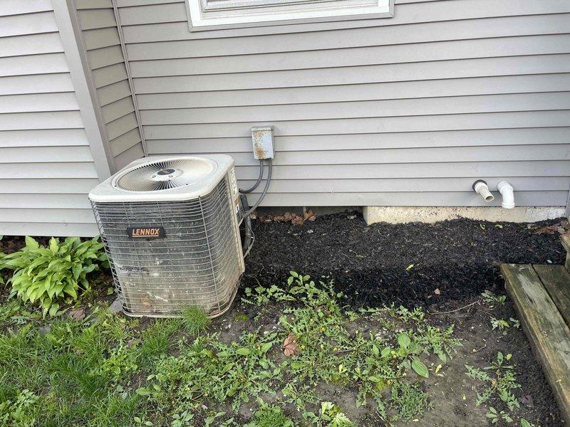 Conducted on-site evaluation of existing Lennox air conditioning system for replacement estimate. Current unit is operational and located with condenser positioned at exterior foundation and electrical panel in basement area. Assessed existing electrical disconnect, conduit routing, and main electrical panel capacity to determine compatibility requirements for new equipment installation.