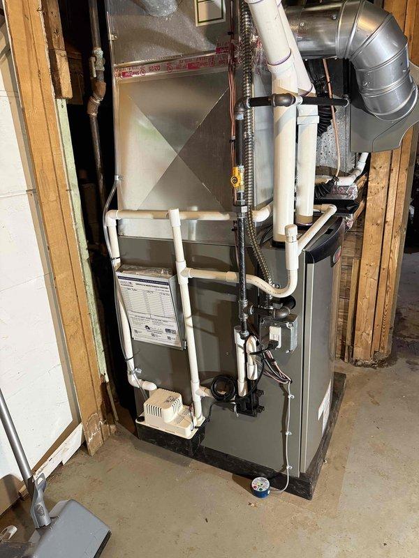 Completed full HVAC system installation including a 110,000 BTU high-efficiency furnace with humidifier and 3.5-ton air conditioning unit. Installed furnace in basement utility area with proper venting using white PVC piping, connected metallic ductwork with pyramid plenum configuration, and mounted all necessary electrical controls and condensate drain lines. Positioned outdoor condenser unit on composite base pad with appropriate clearance from structure, ran insulated refrigerant lines to exterior disconnect box, and reconnected all electrical components. System tested and operational upon completion, with all mechanical permits obtained prior to installation.