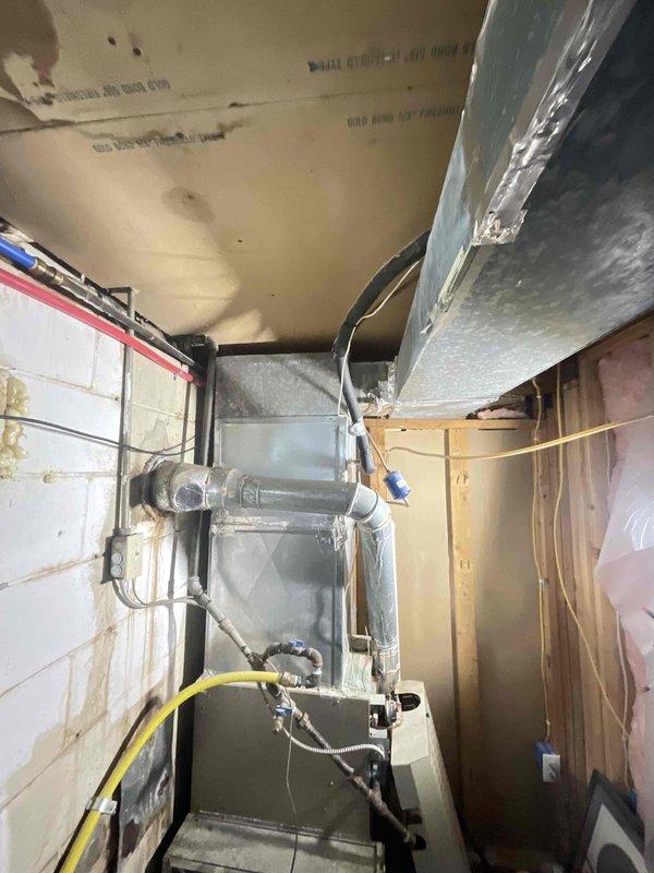 Provided estimate for furnace and air conditioning system replacement in basement location under BOGO promotion. Existing equipment is operational but aged, with current furnace and ductwork system showing signs of wear typical of older installations in unfinished basement utility space with exposed framing and concrete block foundation.