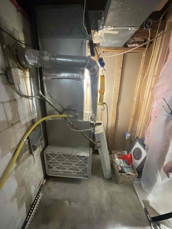 Provided estimate for furnace and air conditioning system replacement in basement location under BOGO promotion. Existing equipment is operational but aged, with current furnace and ductwork system showing signs of wear typical of older installations in unfinished basement utility space with exposed framing and concrete block foundation.