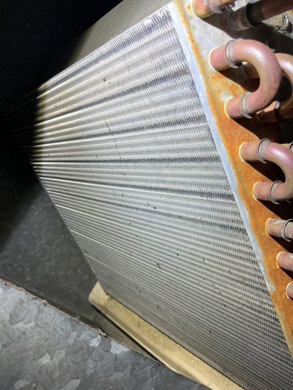 Completed comprehensive air conditioning maintenance tune-up including full system inspection and performance evaluation. Inspected evaporator coil assembly and heat exchanger components, noting copper tubing connections showing typical oxidation consistent with normal system operation. Verified all refrigerant line connections, checked fin condition on coil assembly, and confirmed proper installation of gasket seals and insulation materials. System operational and functioning within normal parameters.