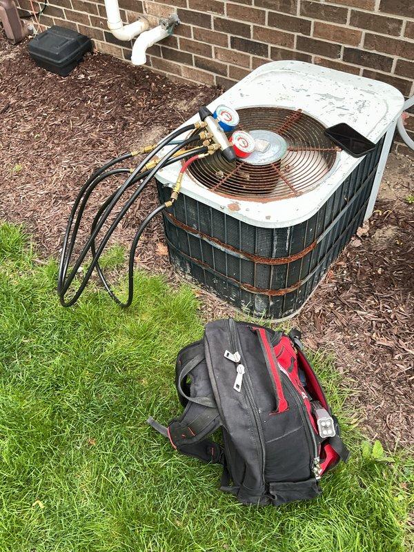 # HVAC Maintenance - ACM

Completed comprehensive spring tune-up on 49-year-old forced air air conditioning system. Upon arrival, system was operating normally. Performed standard preventive maintenance protocol including visual inspection of outdoor condensing unit, which revealed significant age-related corrosion on coil assembly and metal banding, consistent with equipment of this vintage.

Connected manifold gauge set to service ports and recorded operating pressures and temperatures. Evaluated refrigerant charge levels and system performance parameters. Inspected condenser coil for debris accumulation and airflow restrictions. Examined electrical connections, contactors, and capacitor condition. Verified proper operation of condenser fan motor and compressor.

Checked refrigerant line insulation and service valve integrity. Assessed condensate drain line for proper drainage. Inspected mounting hardware and cabinet condition, noting exterior weathering and rust formation on metal c
