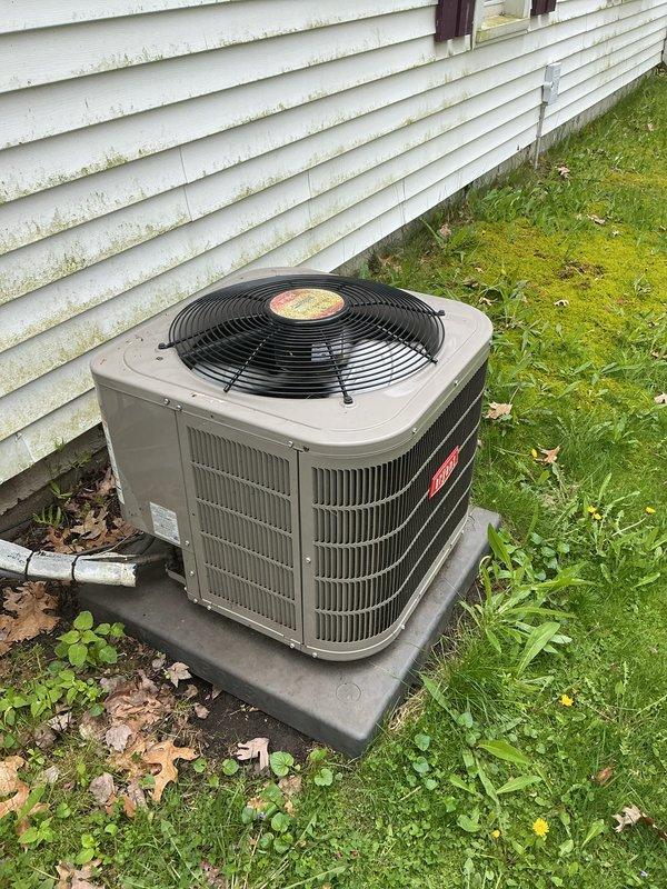 Completed seasonal air conditioning maintenance and tune-up on outdoor condensing unit as part of annual service plan. System was operational upon arrival. Performed comprehensive inspection of beige/tan condenser unit including examination of fan motor assembly, condenser coils with vertical fins, electrical connections, and refrigerant levels. Verified proper operation of compressor and condenser fan with black circular guard. Inspected unit mounting on polymer pad for stability and proper drainage. Checked PVC condensate line for clear flow and proper drainage away from foundation. Cleaned debris including leaves and organic matter from around unit base and verified adequate clearance from house siding for proper airflow. System tested and confirmed operating within normal parameters, ready for cooling season.