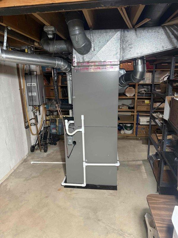 Completed full HVAC system installation including a Lennox 110,000 BTU furnace and 3.5-ton air conditioning unit with right-side configuration in basement utility area. Installed furnace on drain pan with proper condensate drainage using white PVC piping, connected supply and return ductwork to unit top, and routed refrigerant lines with black insulation to outdoor condenser. Reconnected humidifier to new system, established all electrical connections, and verified proper airflow distribution through existing ductwork. All equipment installed per manufacturer specifications with appropriate safety labels visible and accessible for future service.