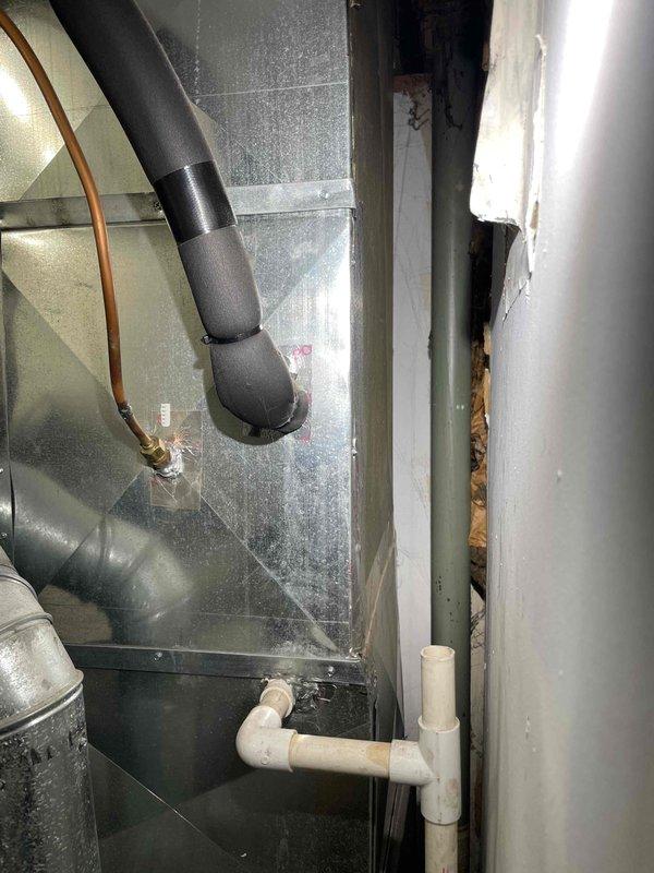 Conducted on-site assessment of non-operational air conditioning system located in basement mechanical room. Evaluated existing 8+ year old equipment, photographed current installation including refrigerant lines, ductwork connections, and air handler configuration. Provided replacement estimate for complete AC system upgrade, documenting existing copper linesets, PVC condensate drainage, and confined space installation requirements for proper equipment sizing and installation planning.