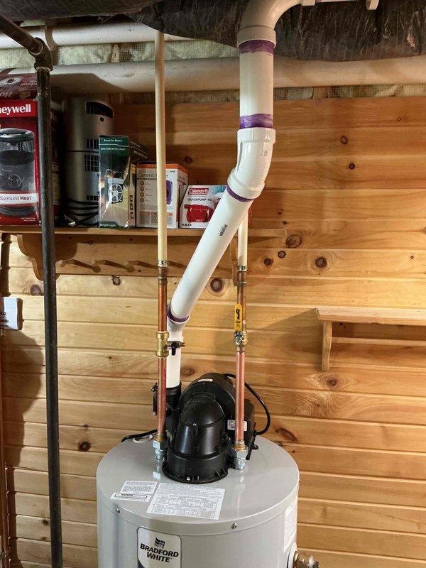 Installed a Bradford White 40-gallon power vent water heater with 40,000 BTU capacity and 6-year tank warranty in basement utility area. Removed existing water heater and completed full installation including 20 feet of PVC venting with proper primer application at all joints, brass fittings, and copper pipe connections to integrate with existing plumbing system. Venting system was routed through building exterior with appropriate termination point, ensuring proper exhaust ventilation for power vent unit.