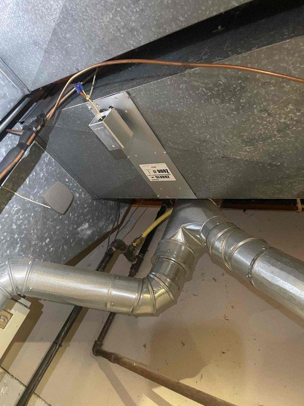 Provided estimate for replacement of 17-year-old non-functional air conditioning system with outdoor condenser unit located at exterior foundation and indoor air handler/ductwork installed in basement. Assessed existing natural gas furnace system and HVAC infrastructure including refrigerant lines, electrical connections, and metallic ductwork with plenum configuration to determine compatibility and replacement requirements for complete cooling system installation.