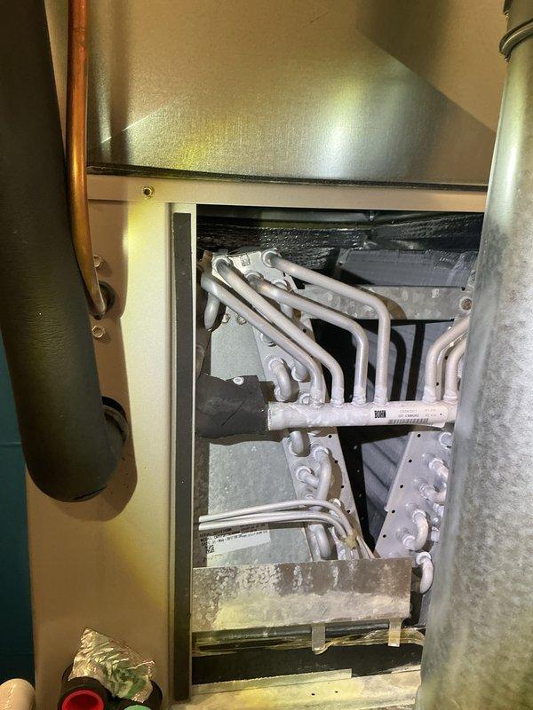 Completed annual cooling maintenance on Bryant residential HVAC system. Performed comprehensive inspection of furnace and air handler components, including heat exchanger examination which revealed normal dust accumulation consistent with system age and operation. Cleaned and inspected serpentine heat exchanger tubes, verified proper airflow pathways, and checked all accessible internal components for wear or damage. Inspected PVC condensate drainage system with red-handled valves for proper operation and clearances. Verified electrical connections at junction box and control panel. Examined all copper refrigerant lines and ductwork connections for secure mounting and proper insulation. Confirmed adequate equipment clearances and proper ventilation in utility room installation. System operating within normal parameters with no immediate service needs identified. Equipment showing typical wear patterns for age with no safety concerns noted. All components accessible for future maintenan