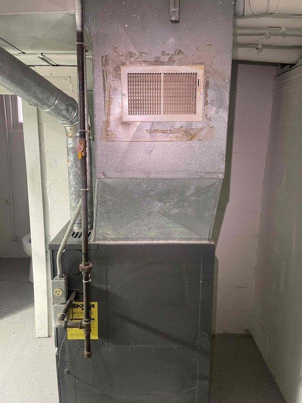 Provided estimate for BOGO furnace and air conditioning system replacement in basement location. Current furnace is non-operational and aged beyond serviceable life, with no existing air conditioning system present. Assessment included evaluation of existing gray metal furnace unit, return air vent configuration, and ductwork infrastructure to determine equipment specifications and installation requirements for complete HVAC system upgrade.