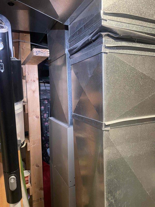 Conducted comprehensive estimate assessment for complete HVAC system replacement involving 28-year-old furnace and air conditioning unit, both original to the home and at end of serviceable life. Documented existing equipment configuration including air handler with diamond-pattern embossed metal panel, black flexible ductwork, refrigerant line routing, and electrical panel specifications showing main breaker configuration and circuit distribution. Photographed mechanical room layout, equipment positioning between wooden framing and concrete block wall, utility space constraints, and existing electrical infrastructure to provide accurate replacement recommendations for coordinated furnace and AC system upgrade.