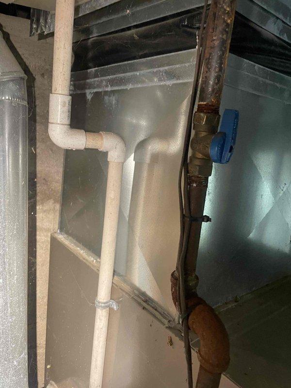 Conducted on-site evaluation for air conditioning system installation at property currently without cooling equipment. Assessed existing furnace infrastructure in basement utility area, noting aged mechanical room with vertical furnace unit, metallic ductwork, and available electrical service. Evaluated installation requirements including outdoor condenser placement, refrigerant line routing, condensate drainage integration with existing PVC plumbing system, and electrical supply compatibility. Documented existing HVAC infrastructure including furnace configuration, duct system layout, and basement mechanical space constraints. Photographed installation area to determine equipment sizing requirements and identify any structural or accessibility considerations for new AC system integration with current heating equipment. Property inspection completed in preparation for comprehensive replacement estimate.