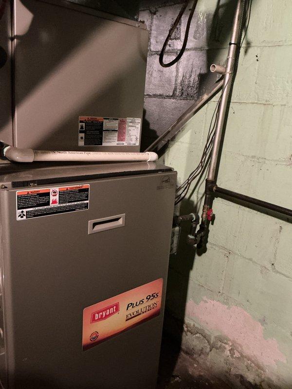 Completed annual cooling maintenance on Bryant Plus 95s Evolution system. Inspected and photographed air filter showing clean diagonal crisscross mesh material properly installed in housing frame. Verified furnace and air handler installation, checked all visible components including PVC condensate lines, electrical connections, and refrigerant lines for proper operation and secure mounting.