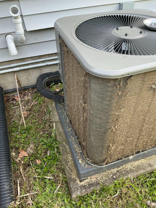 Completed annual cooling maintenance on outdoor condensing unit. Condenser coils were heavily soiled with accumulated dirt, dust, and debris, significantly restricting airflow through the fin surfaces. Thoroughly cleaned and degreased exterior coil fins to restore proper heat transfer efficiency. Removed debris buildup from base pan including leaves, twigs, and organic matter. Inspected fan operation and verified proper motor function. Unit operational upon completion with improved airflow and heat rejection capability.