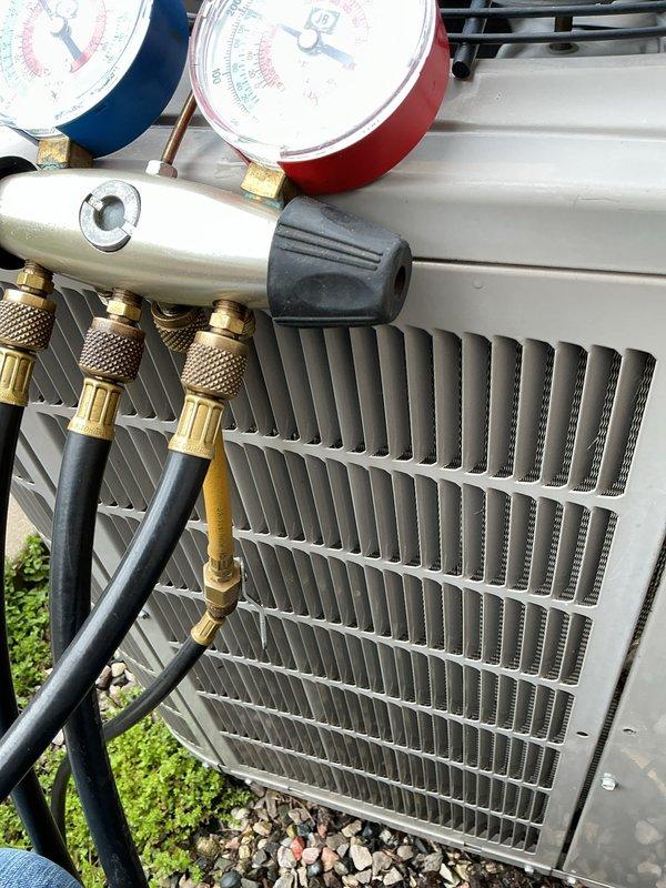 Completed scheduled air conditioning maintenance on outdoor condensing unit. Performed refrigerant pressure diagnostics using manifold gauge set, inspected condenser coil condition, and verified proper system operation. Unit operational with no deficiencies noted at time of service.