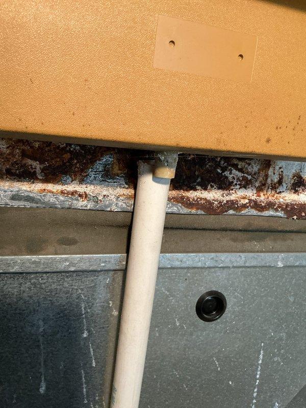 Responded to callback for furnace water leak. Upon inspection, discovered extensive rust and corrosion on horizontal condensate drain components and air handler housing. Documented significant oxidation on metal brackets and deterioration at foam insulation interface points. Heavy rust accumulation and mineral deposits indicate prolonged moisture exposure from condensate system failure. Photographed corroded areas including drain line connections and compromised metal surfaces for warranty documentation and further assessment of unit integrity.