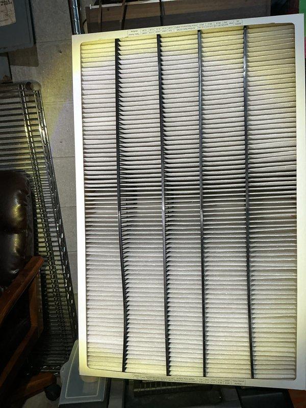 Completed annual cooling maintenance inspection and filter replacement. Accessed evaporator compartment housing and replaced dirty pleated air filter showing significant dust accumulation and discoloration at edges. Documented equipment condition with photos for service records.