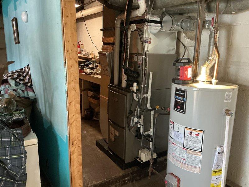 Completed full HVAC system installation in basement mechanical room, installing new 70,000 BTU gas furnace and 1.5-ton air conditioning unit in left-side configuration. Connected all necessary gas lines, electrical conduit, refrigerant lines, and integrated ductwork to existing distribution system. Reconnected all mechanical components and verified proper operation of complete heating and cooling system.